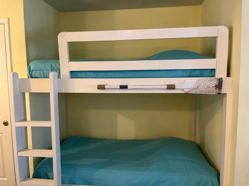 two bunk beds in a room with a ladder at Affordable SPI family condo - walking distance to the beach, Sleeps 6, Third Floor, 2025 Traveler Award in South Padre Island
