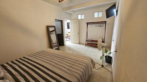 ein Schlafzimmer mit einem Bett und ein Badezimmer mit einem Spiegel in der Unterkunft Meraky in Oaxaca de Juárez