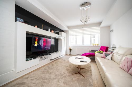 ein Wohnzimmer mit Couch und Fernseher in der Unterkunft Modern Stay in the City Center in Sarajevo