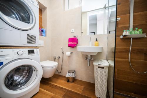 a bathroom with a washing machine and a sink at Modern Apartment In City Center in Sarajevo