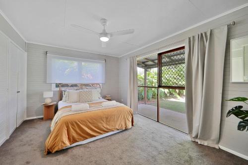 a bedroom with a bed and a sliding glass door at The Hideaway in Bargara