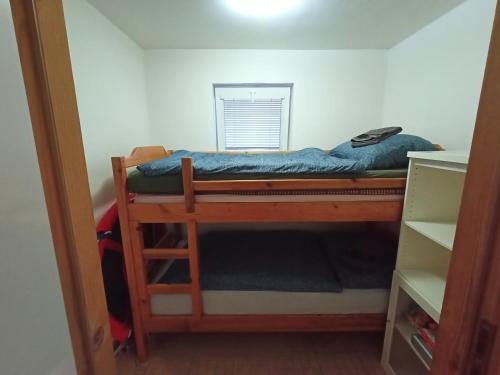a small bedroom with a bunk bed in a room at Kamenec chata Thermal in Kaluža