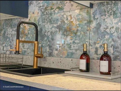 two bottles of wine sitting on a counter next to a sink at Large villa sleeping 8 under 5 minute walk to beach in Caister-on-Sea