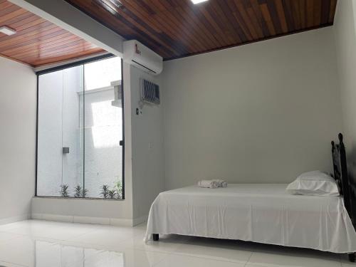 a bedroom with a bed and a large window at Cama & Café Parecis in Campo Novo do Parecis