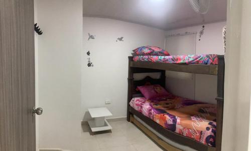 a bedroom with two bunk beds and a table at Apartahotel SANGIL in San Gil