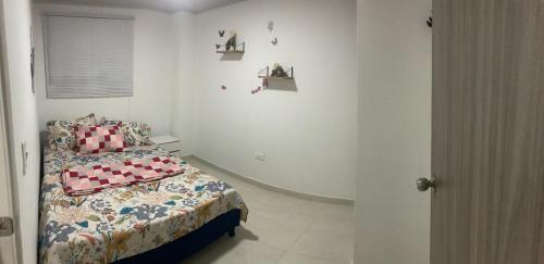 a bedroom with a bed and some pictures on the wall at Apartahotel SANGIL in San Gil