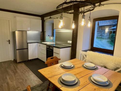 a kitchen with a wooden table with plates on it at Little Farm Apartments in Feldkirchen in Kärnten