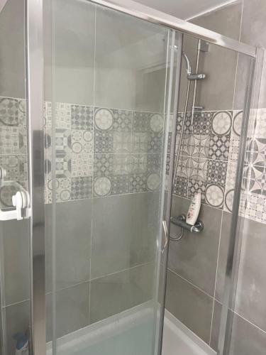 a shower with a glass door in a bathroom at Private room in London