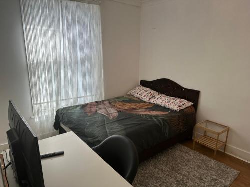 ein kleines Schlafzimmer mit einem Bett und einem Fenster in der Unterkunft Private room in London