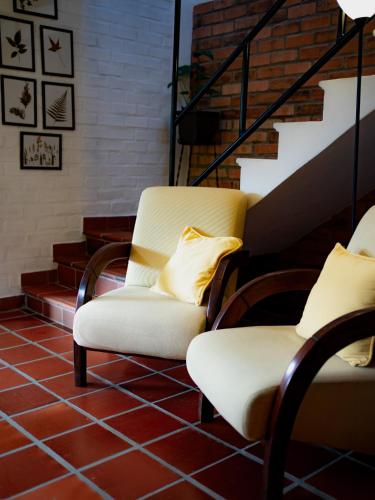 two white chairs sitting next to a staircase at villa luz de vida in Silvia