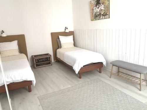 - une chambre avec 2 lits jumeaux et une table dans l'établissement La Demeure des Artistes - Quartier historique, à Saintes