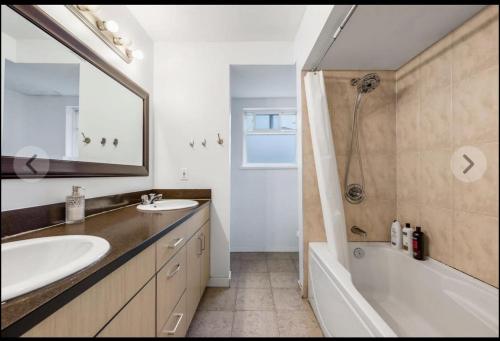 La salle de bains est pourvue de 2 lavabos, d'une baignoire et d'une douche. dans l'établissement one bedroom one bathroom and one kitchen with independent access, à Richmond