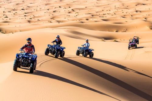 een groep mensen die op atvs rijden in de woestijn bij Desert Villa Boutique Hotel Merzouga in Merzouga
