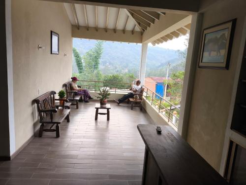 dwie osoby siedzące na balkonie domu w obiekcie Casa de campo Sueño Amatista w mieście Gachetá
