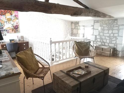 sala de estar con 2 sillas y mesa de centro en La Demeure des Artistes - Quartier historique, en Saintes