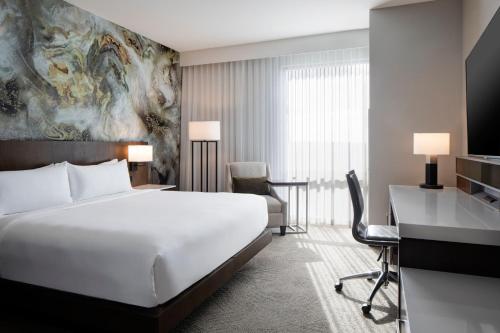 a hotel room with a large bed and a desk at Delta Hotels by Marriott Dallas Southlake in Southlake