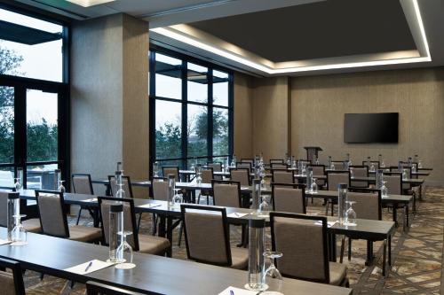 a conference room with tables and chairs and a screen at Delta Hotels by Marriott Dallas Southlake in Southlake
