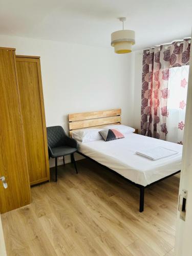 a bedroom with a bed and a chair in it at Manchester City Centre Town House in Manchester