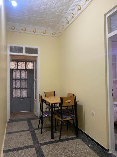 a dining room with a table and chairs and a door at La casita de Larache in Larache