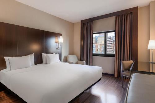 a hotel room with a large white bed and a window at AC Hotel Zamora by Marriott in Zamora