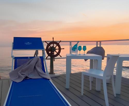a deck with a table and two glasses of wine at Hotel Miramare in Gallipoli