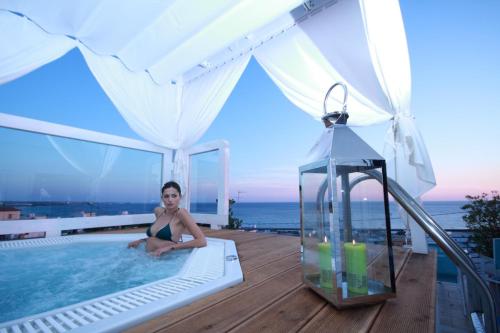 a woman sitting in a swimming pool on top of a house at Hotel Miramare in Gallipoli