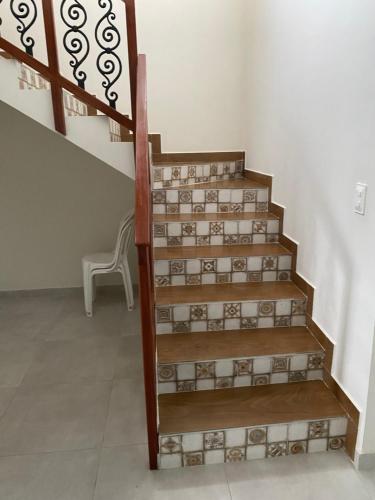 una scala con gradini in legno e una sedia in una stanza di Casa de Campo em Bananeiras-PB a Bananeiras