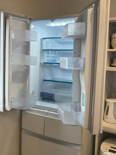 an empty refrigerator with its door open in a kitchen at 広々とした新築戸建 八街駅から徒歩10分車3台駐車可4LDK Free wifi in Yachimata