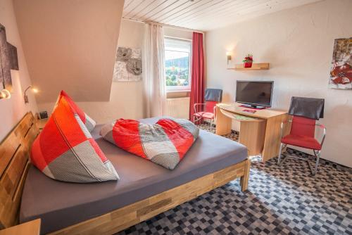 ein Schlafzimmer mit einem Bett mit bunten Kissen darauf in der Unterkunft Haus Quentin in Willingen