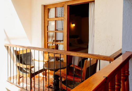 a balcony with a table and chairs and a window at Hotel Diego de Mazariegos in San Cristóbal de Las Casas