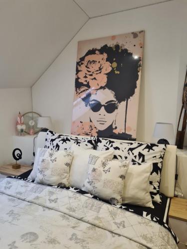 a bed with pillows and a painting on the wall at APARTMENT ZVONÁRSKA with FREE PARKING in Košice
