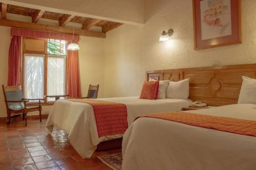ein Hotelzimmer mit 2 Betten und einem Fenster in der Unterkunft Hotel Diego de Mazariegos in San Cristóbal de las Casas