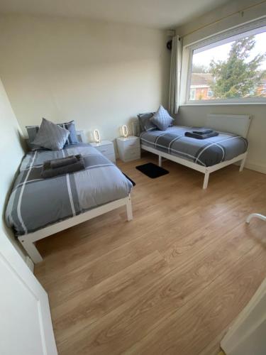 a bedroom with two beds and a window at Spacious three bedroom property in Penrhyn bay - sleeps 6 in Penrhyn Bay