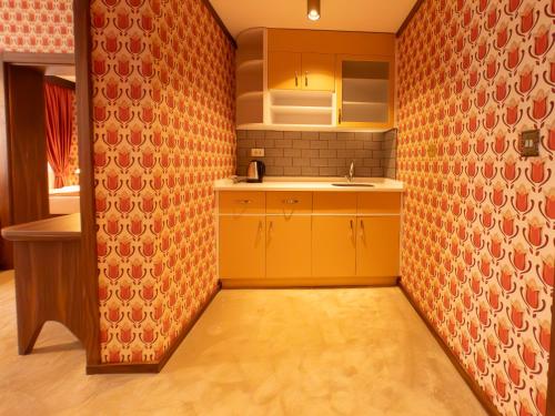 a kitchen with orange walls and yellow cabinets at 74 Museum Hotel in Antalya