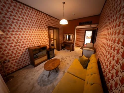 a living room with a yellow couch and a brick wall at 74 Museum Hotel in Antalya