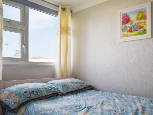 a small bedroom with a bed and a window at Beach View in Kessingland