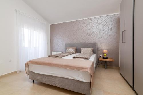 Family friendly house with a swimming pool Gajana, Fazana - 22578 في Mednjan: غرفة نوم بسرير كبير ومصباح على طاولة