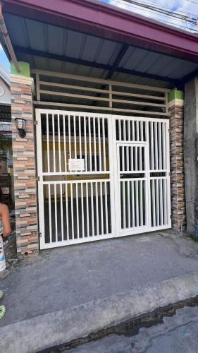 a white gate on a house with a brick wall at Orilla Transient 1 in Mabalacat