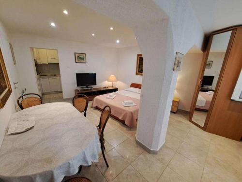 a hotel room with a bed and a table and chairs at Apartments with parking spaces Draga Bascanska, Krk - 22861 in Draga Bašćanska