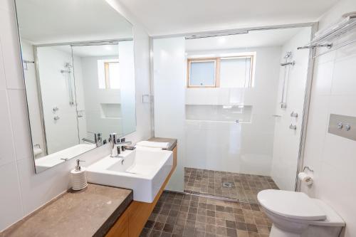 a white bathroom with a sink and a toilet at Powder 2B in Thredbo