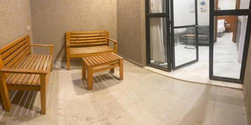 um quarto com dois bancos de madeira e uma janela em شقق درة بارك الشقيق em Ash Shuqayq