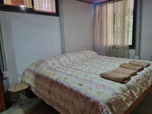 ein Schlafzimmer mit einem Bett mit einer Decke darauf in der Unterkunft Quinta la Inesperada in Aguas Claras