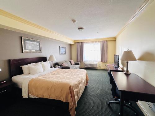 a hotel room with a bed and a desk at Quality Inn & Suites in Hinton