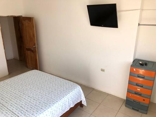a bedroom with a bed and a tv on the wall at Estela, habitación privada de Flor de Lis Beach House in Playas