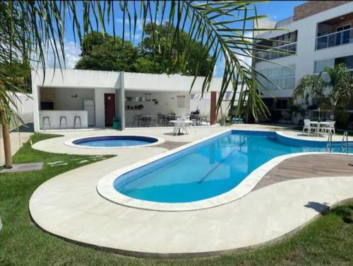 a swimming pool in the yard of a building at Apartamento em Praia do Francês in Praia do Frances