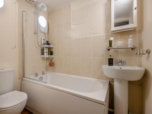 a bathroom with a tub and a sink and a toilet at The Cottage in Ipswich
