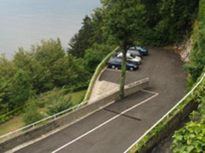 a road with cars parked on the side of it at Hotel Glavjc in Torno