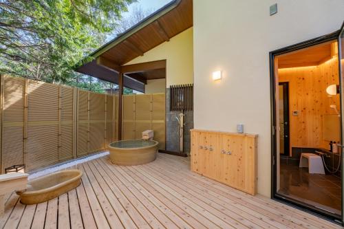 a large bathroom with a tub and a wooden deck at プライベートリゾート犬の日 in Hakone