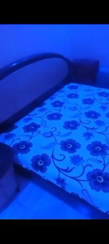 een bed met een blauw laken met bloemen erop bij Apmb in Dakar