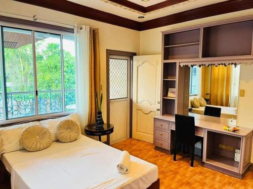 a bedroom with a bed and a desk with a computer at City Villa in Tagbilaran City